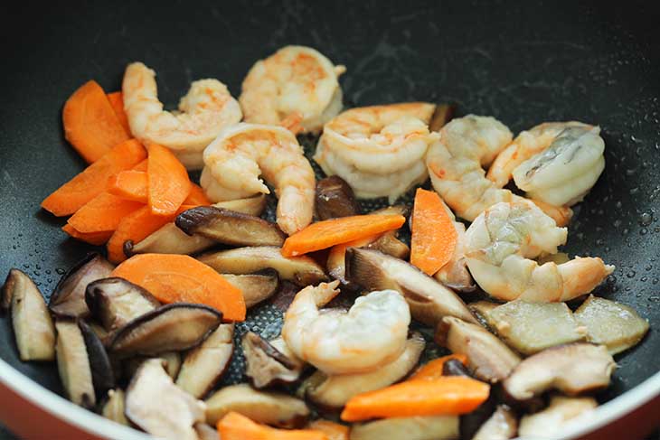 Shrimp ,carrots ,ginger and mushrooms added into the pan.