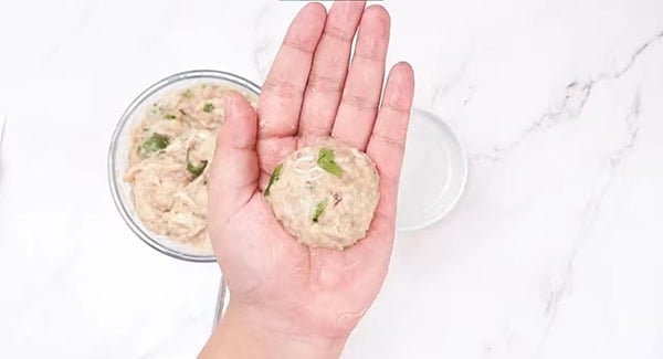 Wet both hands with water and shape the ground chicken mixture into meatballs. 