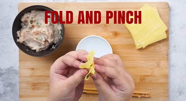 Fold and pinch the edges of the wonton wrapper to seal it tightly. 