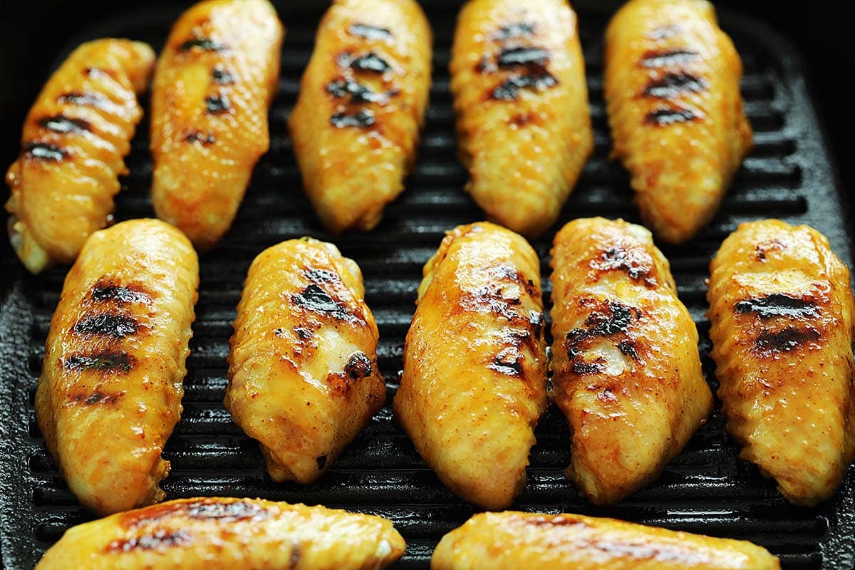 Grill the marinated chicken wings until golden brown. 