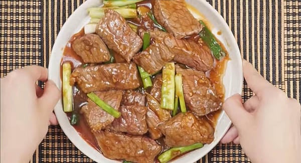 Tender and juicy Mongolian beef with scallions served on a plate. 