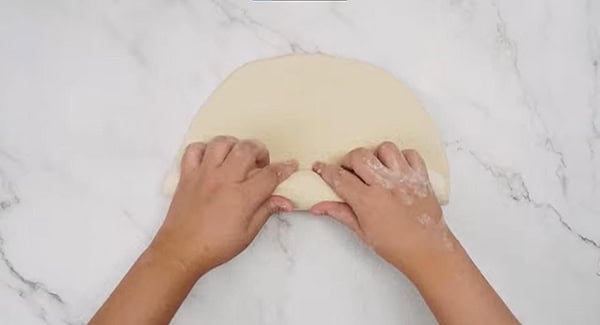 Dough being rolled up in to a log. 