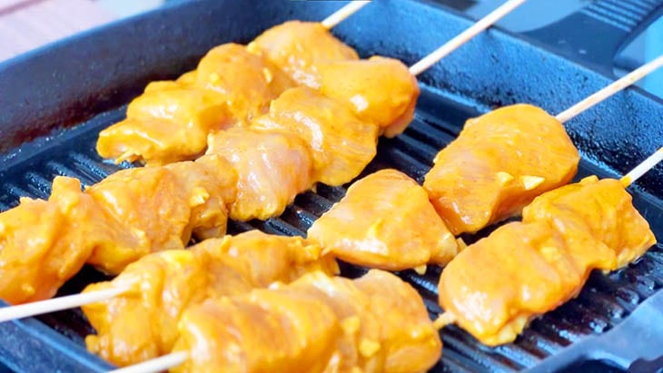 Chicken Sate grilled on a pan.