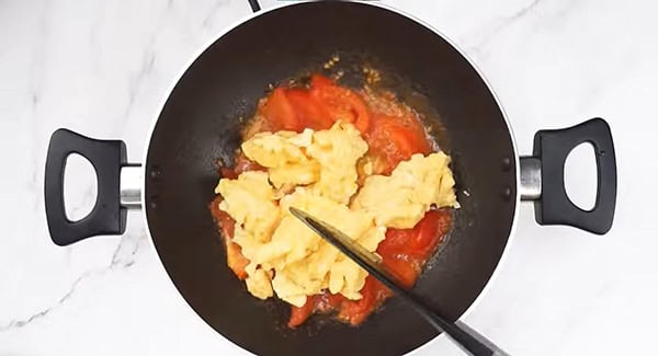 Stir fry the scrambled eggs with the tomatoes. 