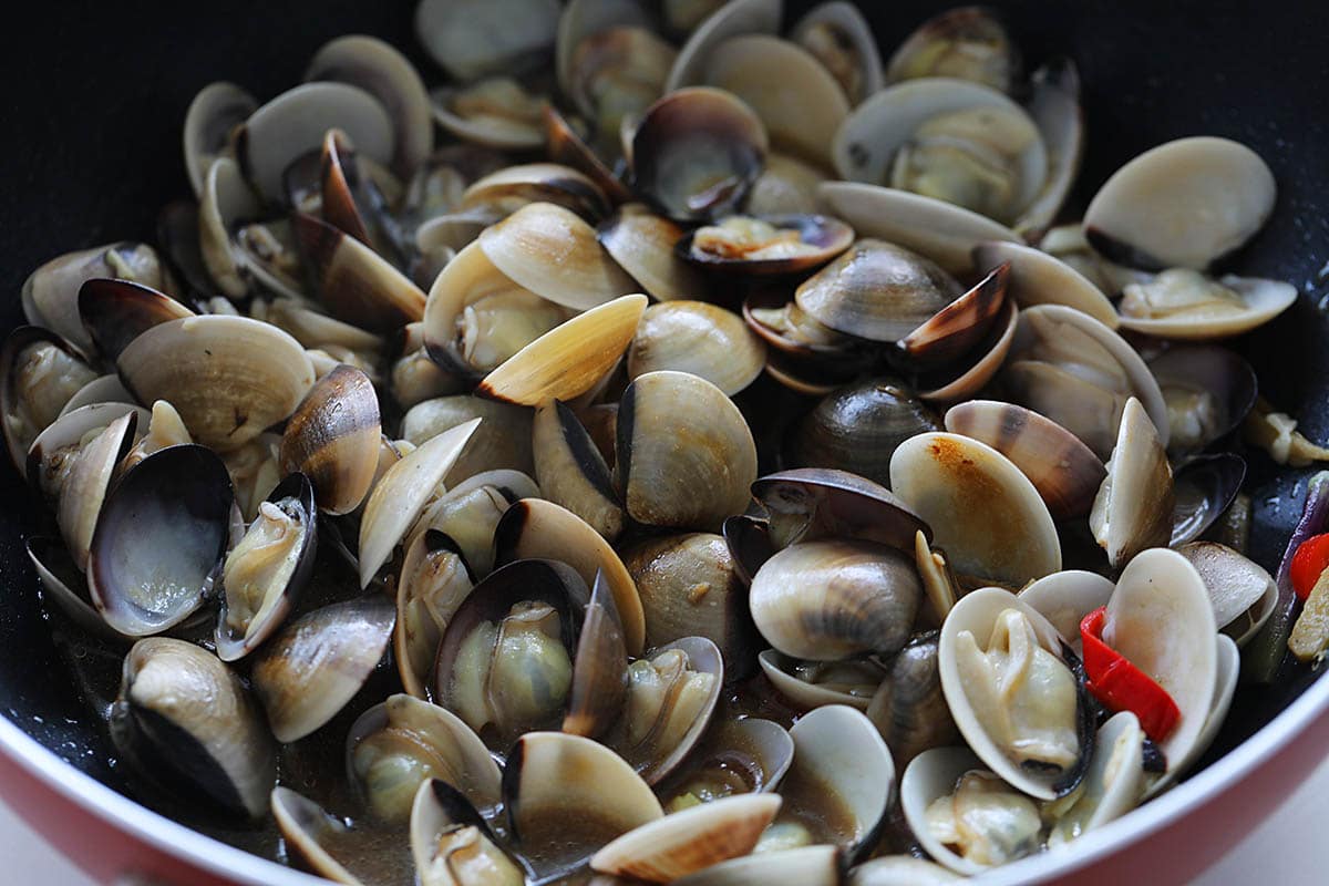 Adding oyster sauce to the clams. 