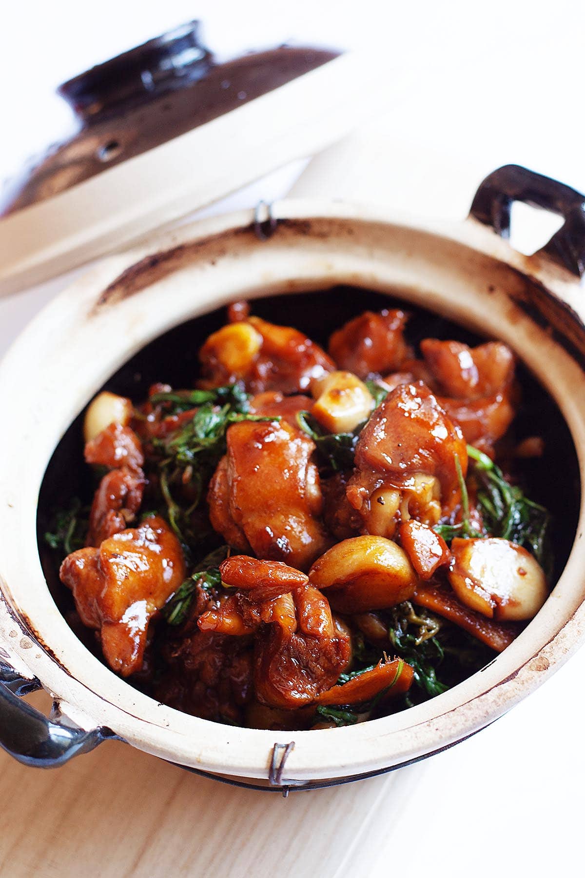 Three cup chicken with chicken, basil leaves in a dark 3-cup chicken sauce.