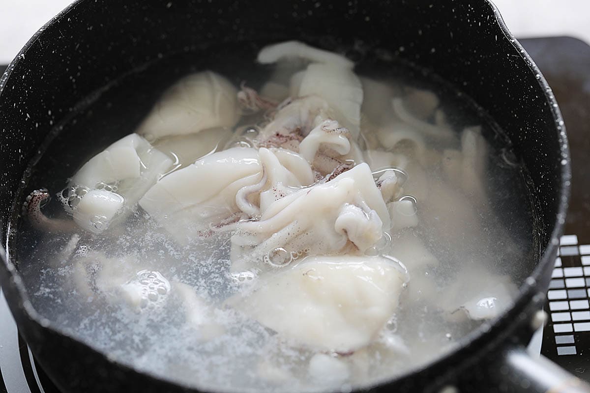 Blanching squid in hot boiling water. 