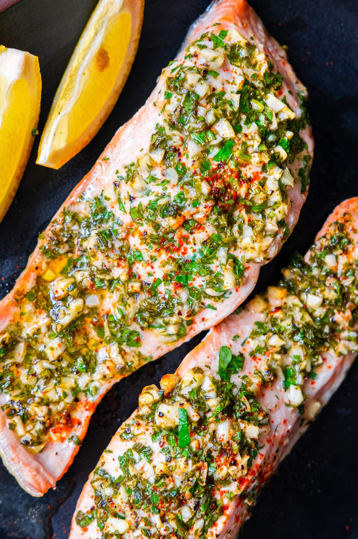 Garlic herb roasted salmon served with lemon wedges. 