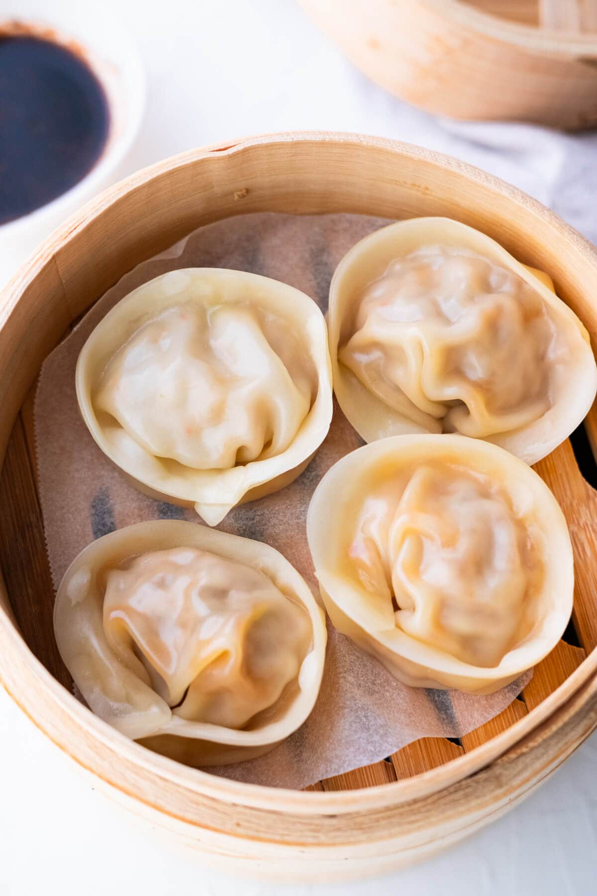 Top down view of Korean kimchi kalbi mandu served with a side of dumpling sauce.