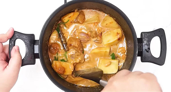 Add coconut milk, potatoes, peanut and basil leaves into the pot.