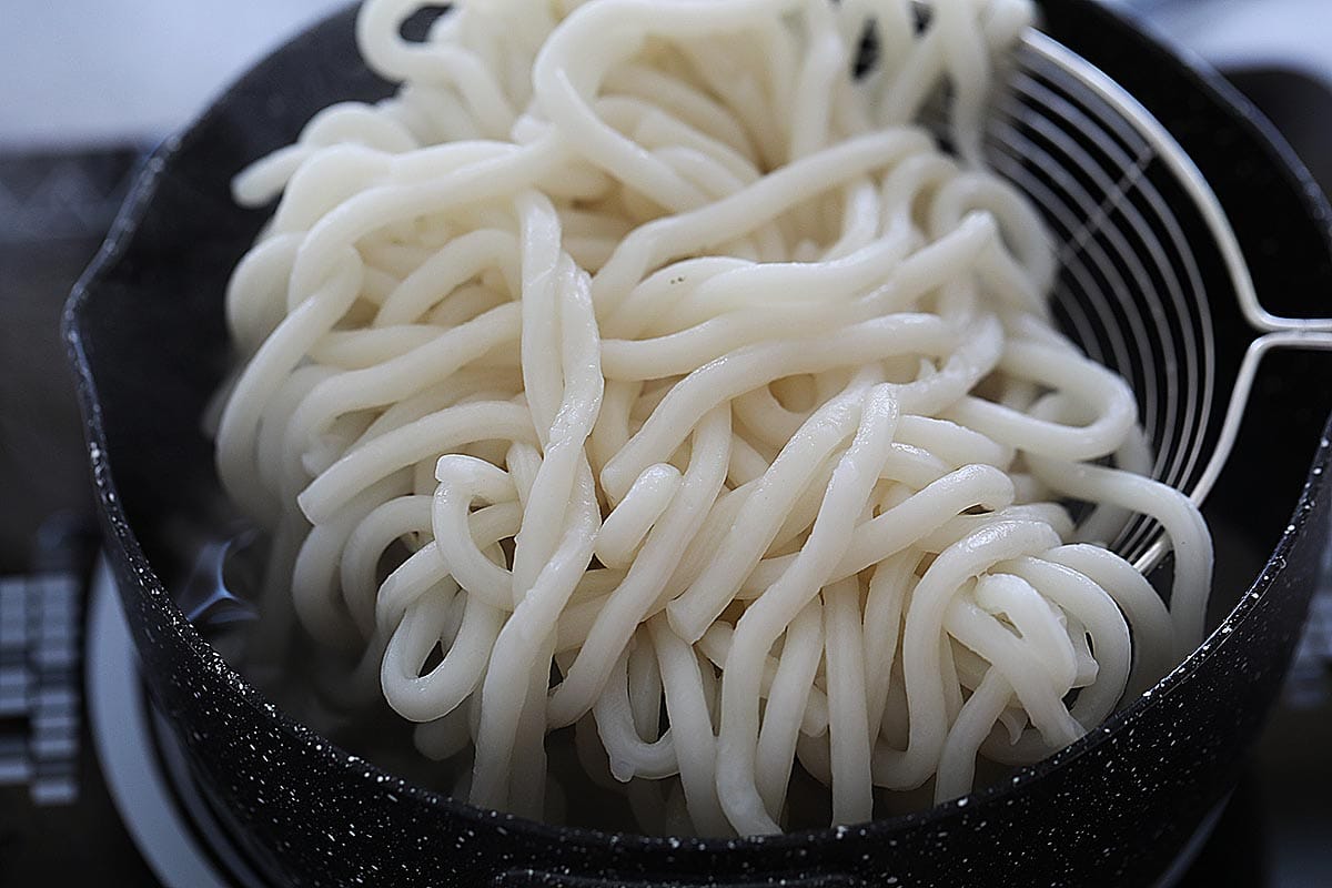 Udon noodles on a strainer.