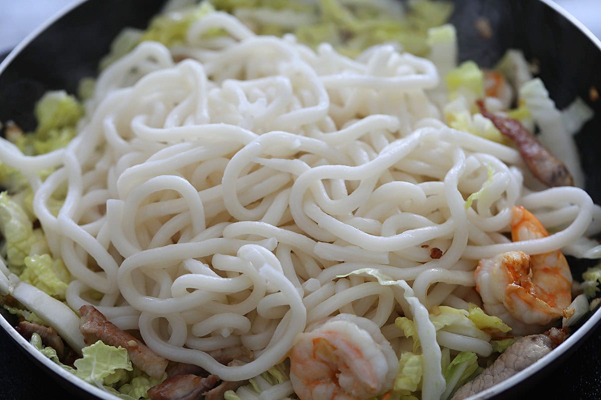 Cooking Hokkien mee in a skillet.