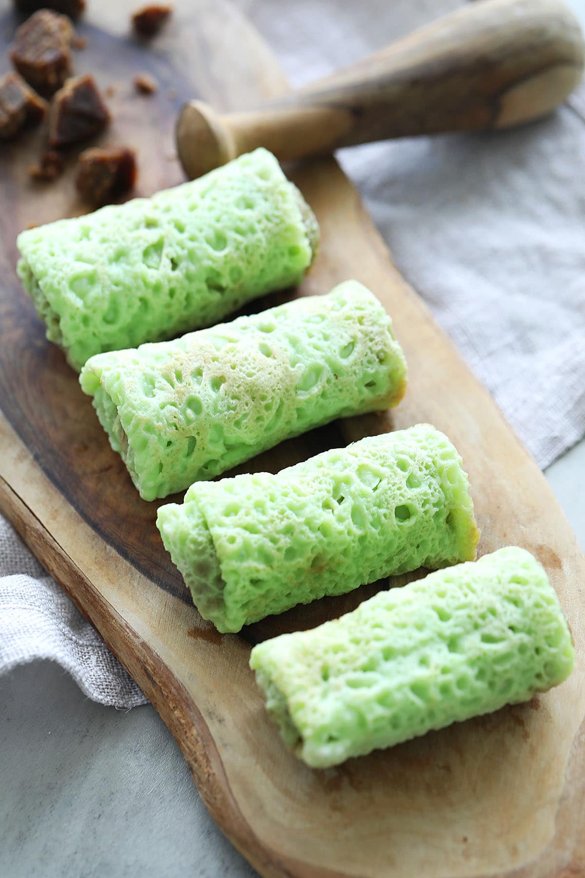 Authentic Malaysian Peranakan kuih dadar gulung on a wood plating.