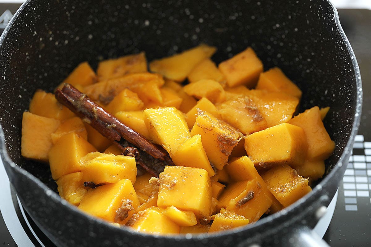 Cooking Indian mango chutney in a sauce pan with spices.