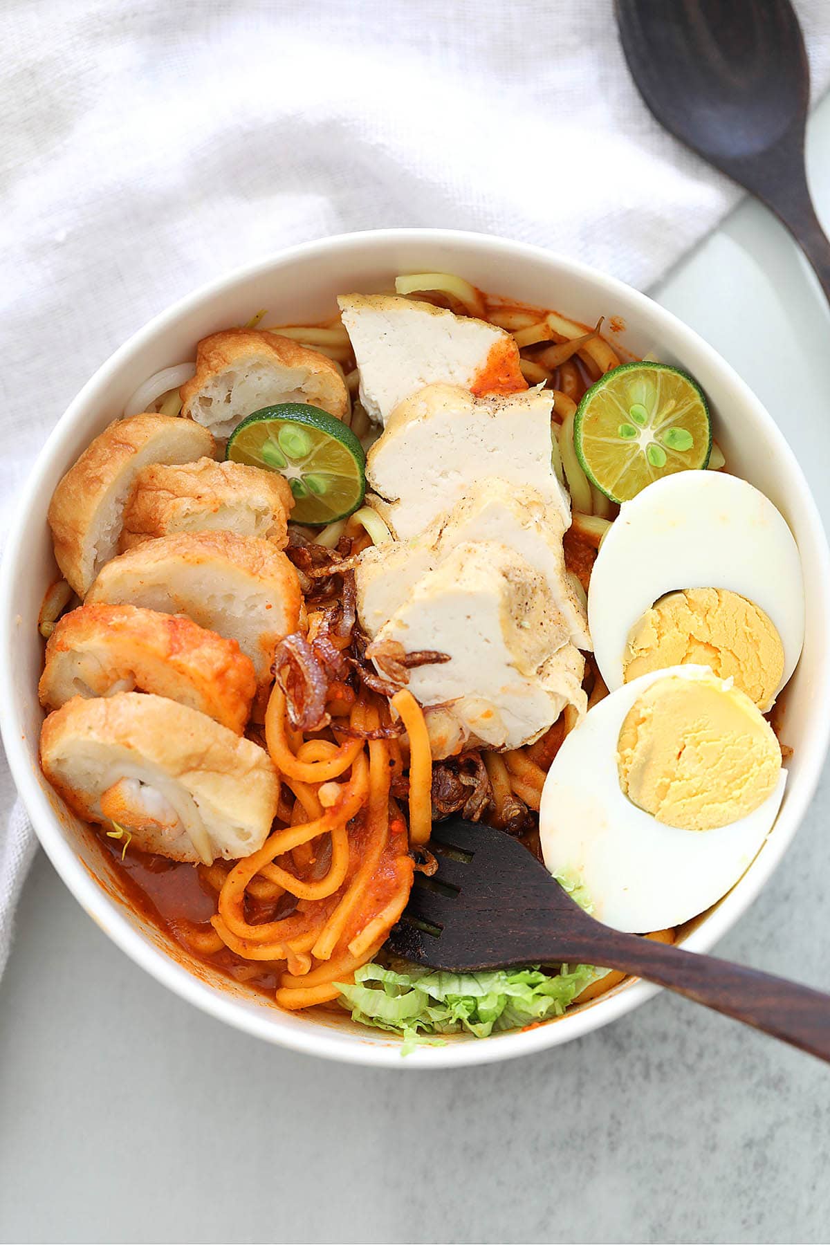 Traditional Malaysian mee rebus recipe with yellow noodles, fritters, fried beancurd and hard-boiled eggs. 