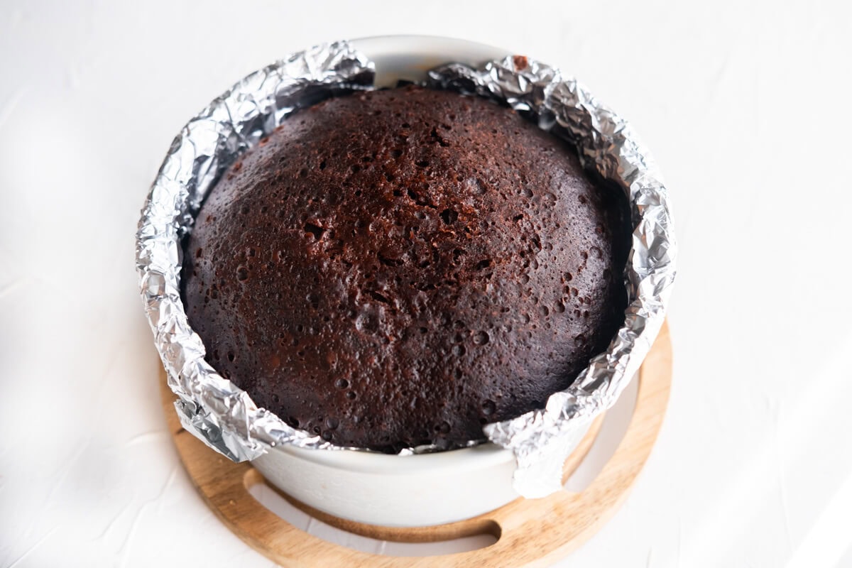 Steamed no bake chocolate cake in a baking pan lined with aluminum foil. 