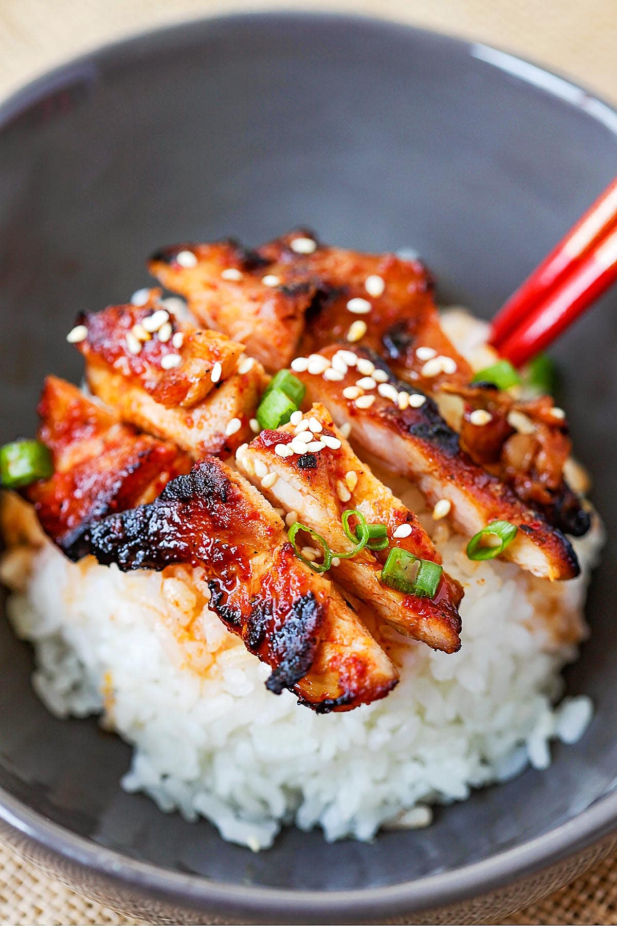 Stir fry Korean spicy chicken with a pair of chopsticks.