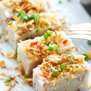 Yam cake cut into pieces and served on a plate.