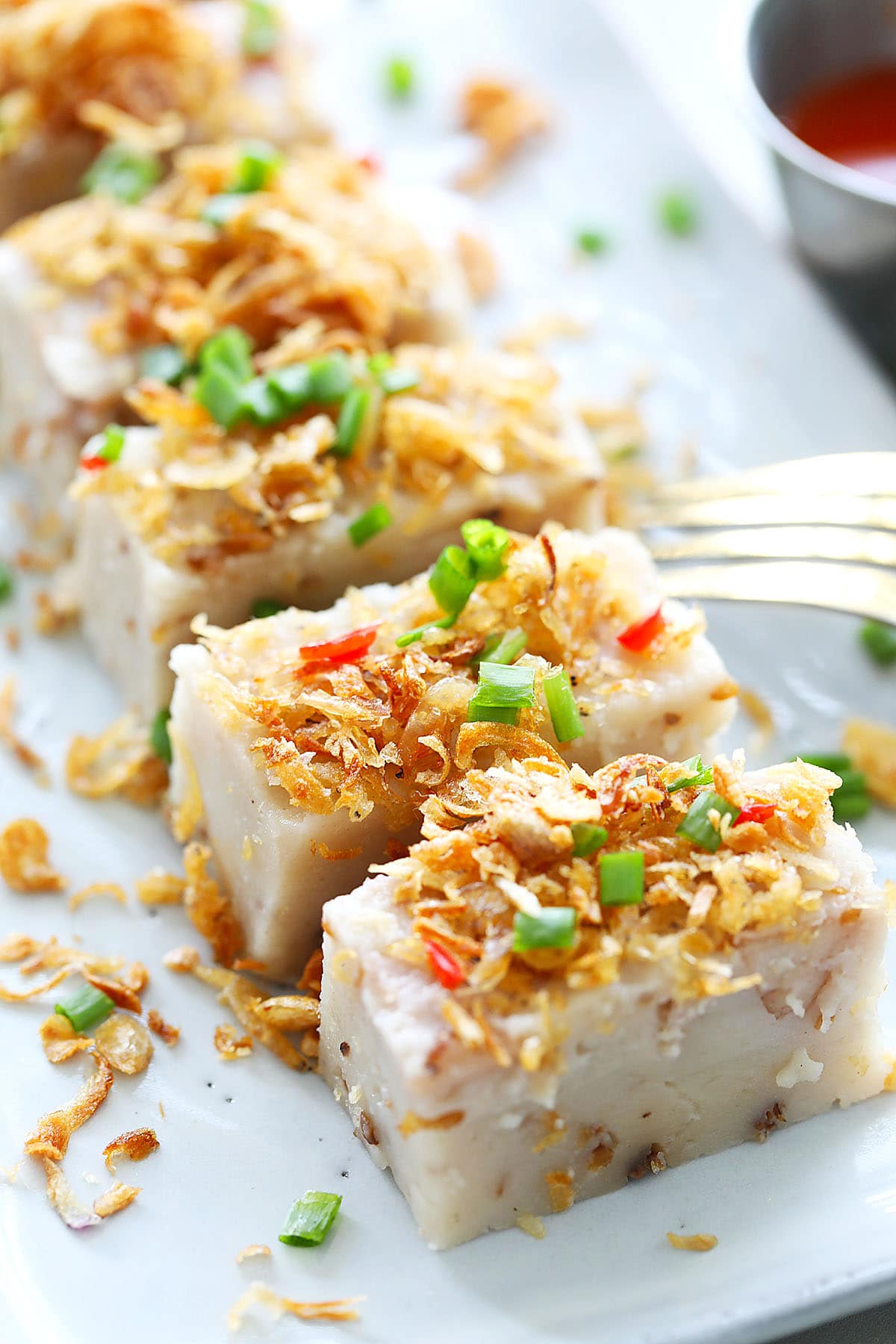 Yam cake cut into pieces and served on a plate.