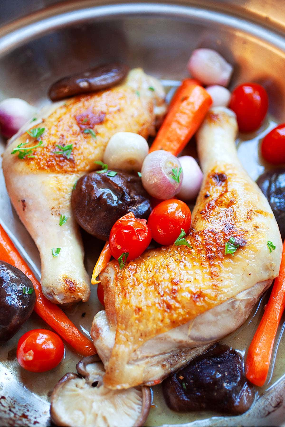 Simple braised chicken recipe with chicken quarters and mushrooms, tomatoes and carrots.