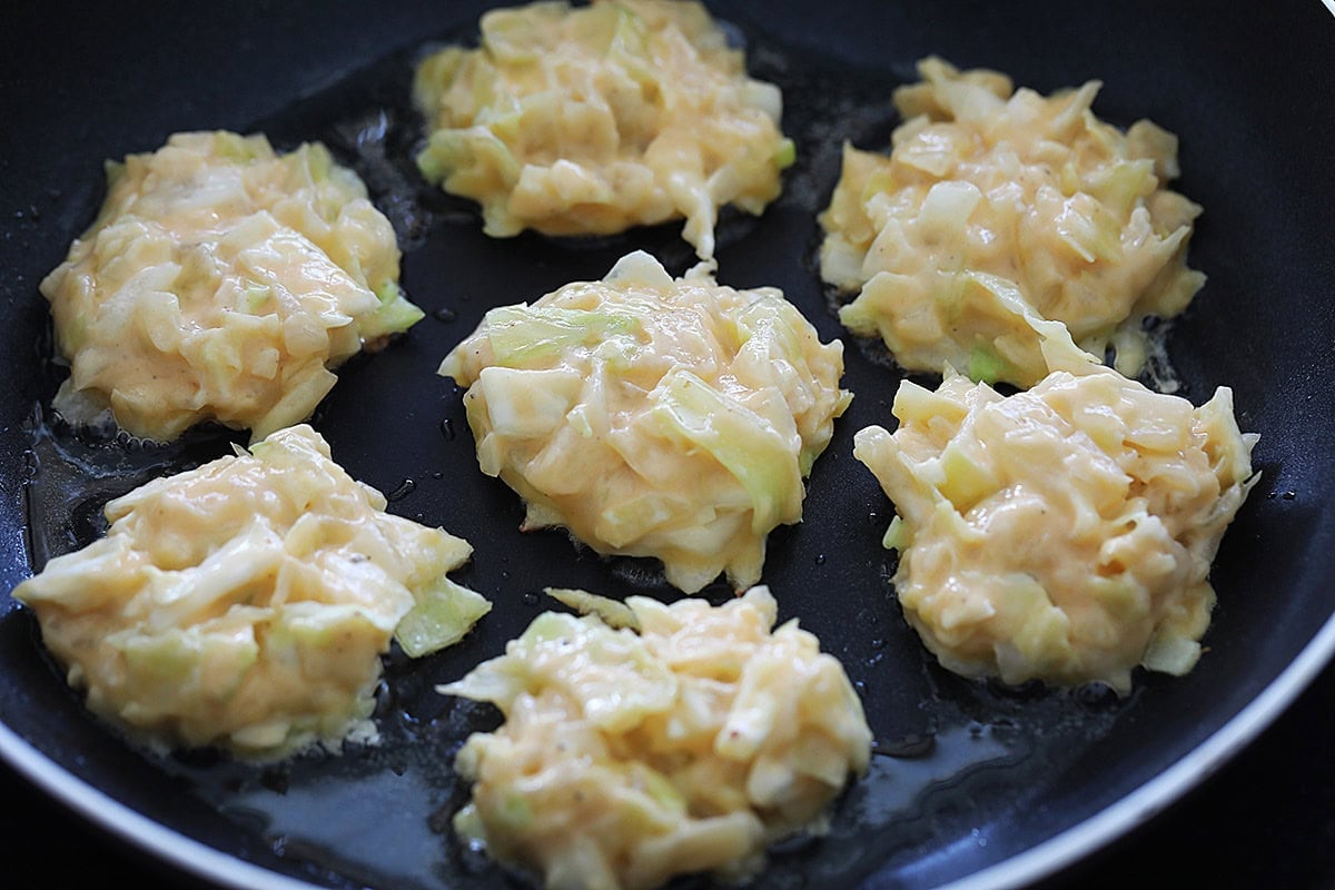 Making cabbage patties on a skillet.