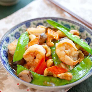 Cashew shrimp stir fry served in a Chinese plate with a pair of chopsticks.