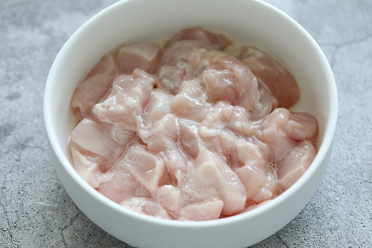 Marinating chicken with Shaoxing wine and cornstarch.