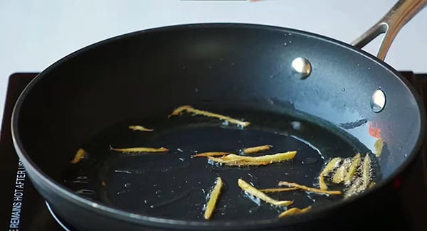 Ginger strips in a skillet.