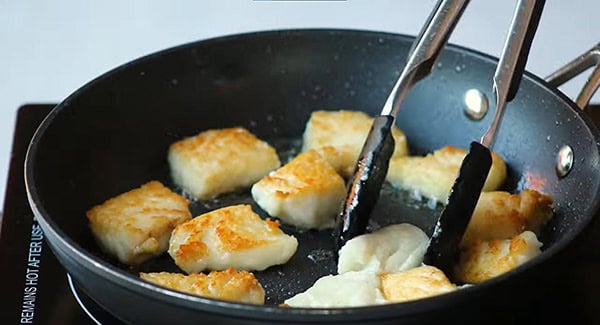 Crispy pan seared fish fillet in a skillet.