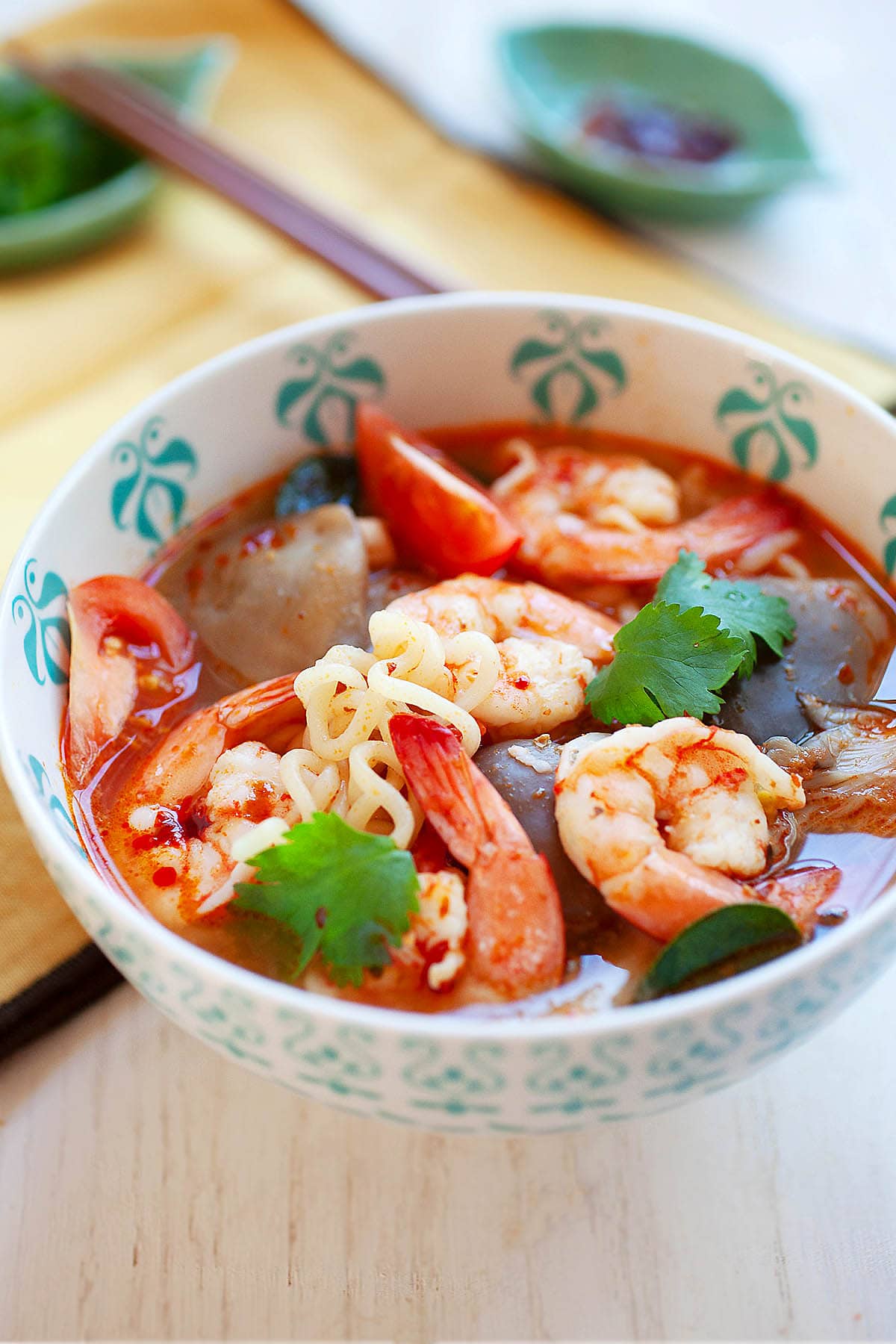 Tom yum noodles in a spicy soup with shrimp and mushrooms.