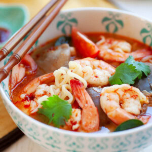 Tomyum noodle soup served in a bowl with a pair of chopsticks.