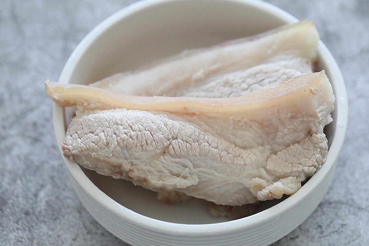 Cooked pork belly in a bowl.