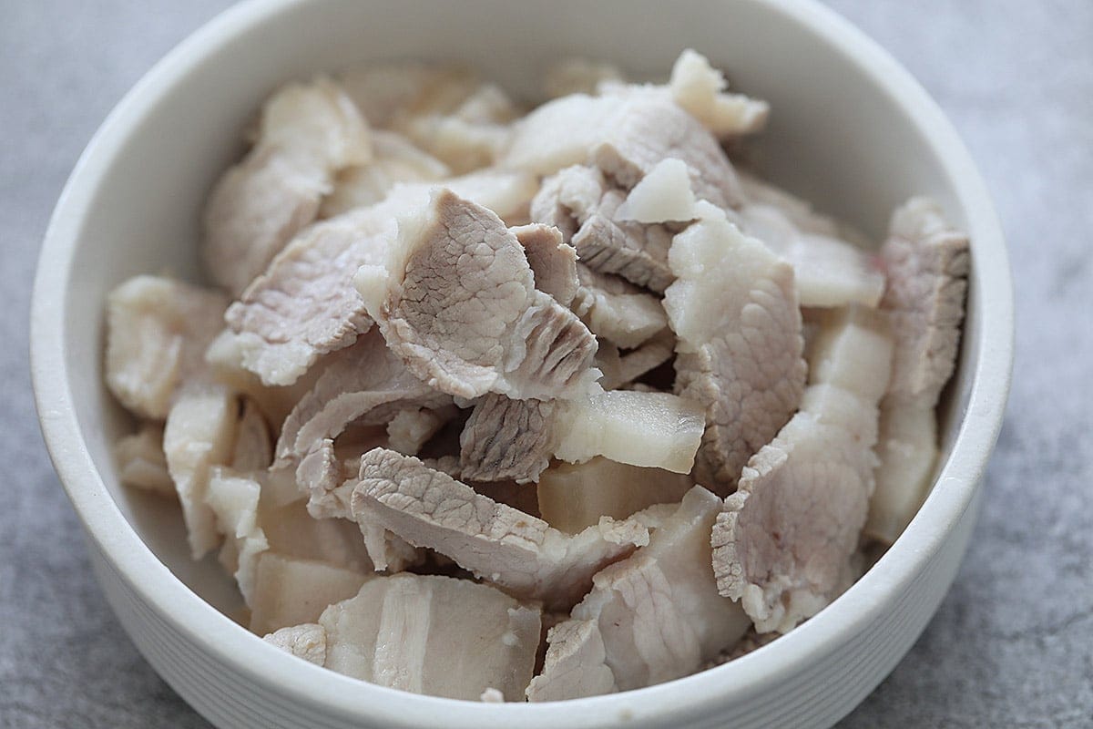 Thinly sliced pieces of pork belly in a bowl.