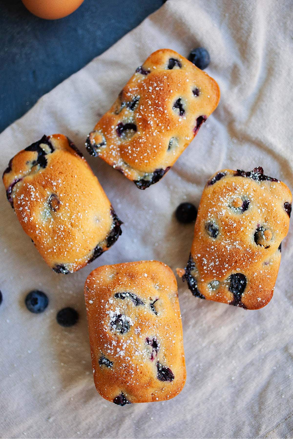 Four blueberry cakelets on a table.