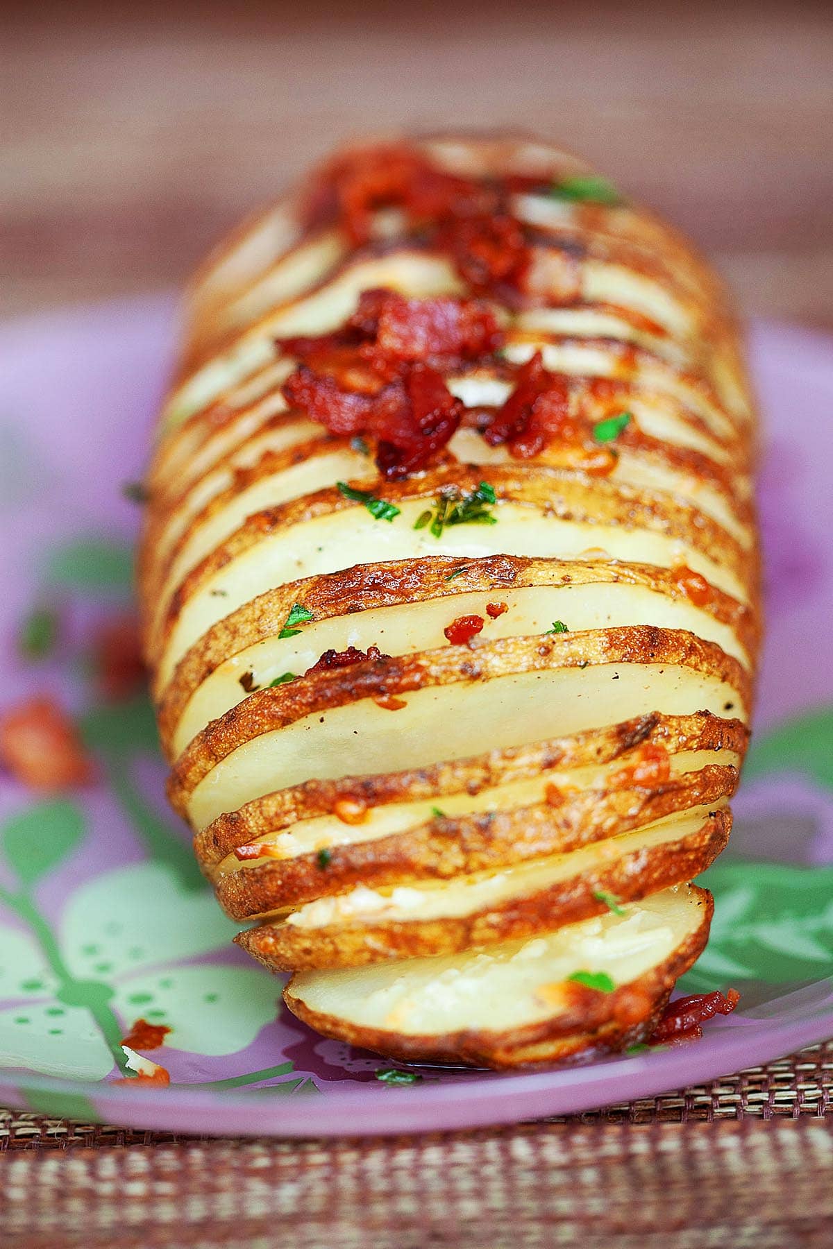 Cheesy Hasselback potatoes with butter, topped with bacon.