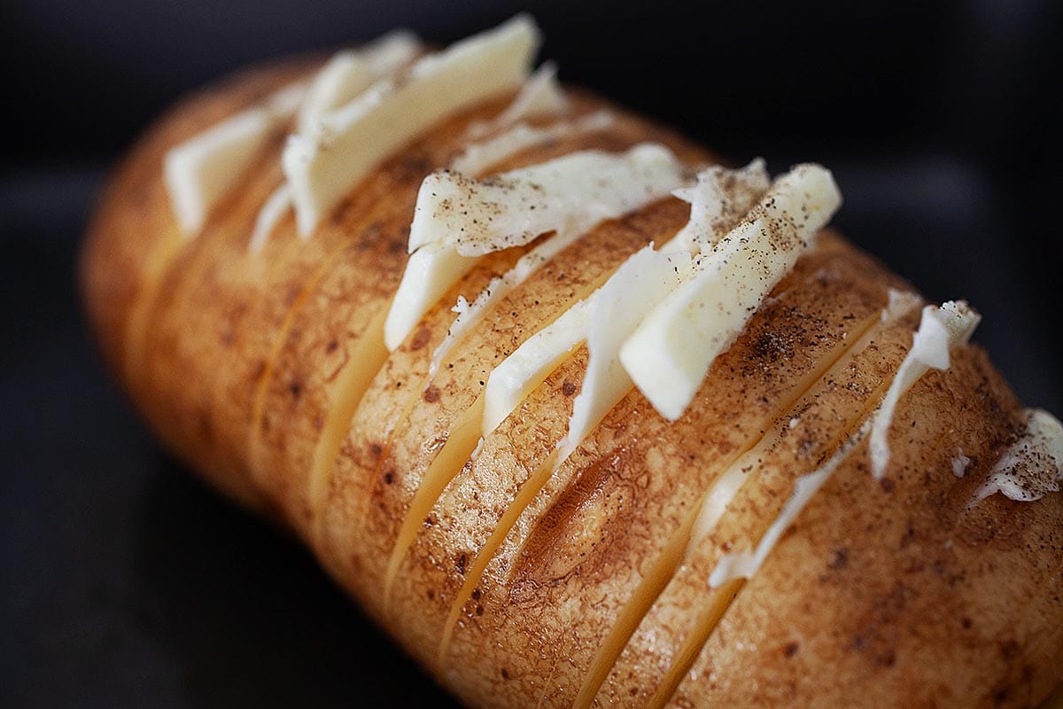 Hasselback potato with thin slices of butter tucked into the slits.