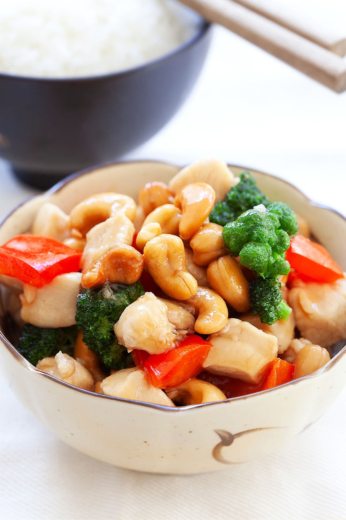 Honey cashew chicken with tender chicken, crunchy cashew nuts, and colorful veggies in a glossy, flavorful sauce, served alongside a bowl of rice.