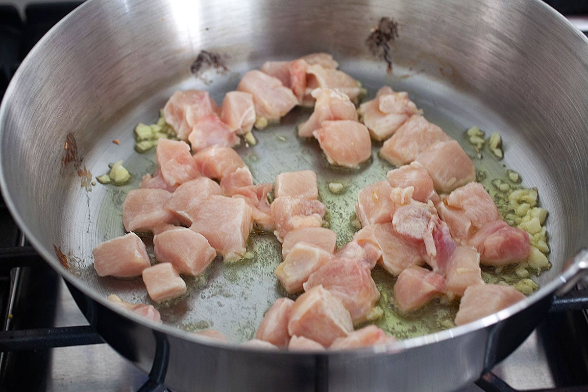 Chicken and garlic in a skillet.