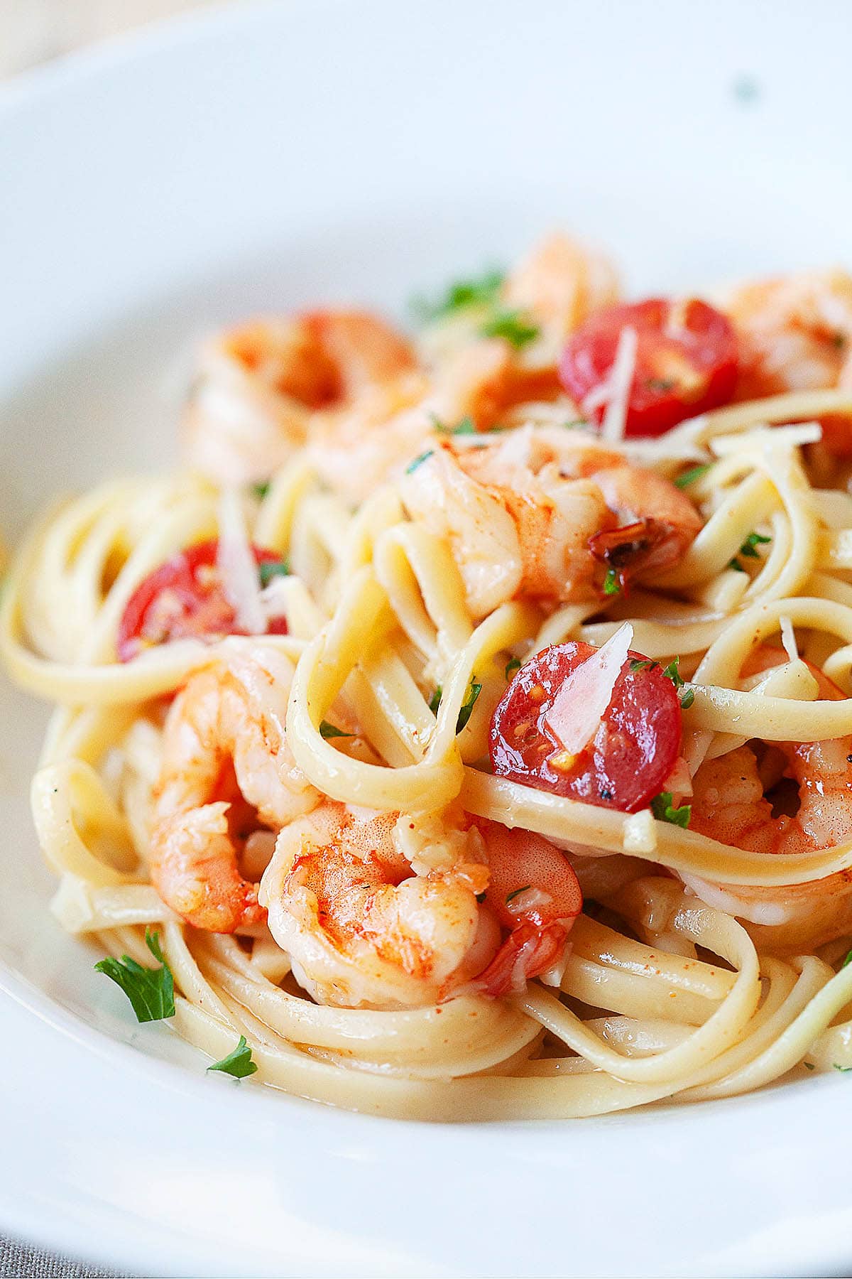 Shrimp scampi and linguine with white wine served on a plate.