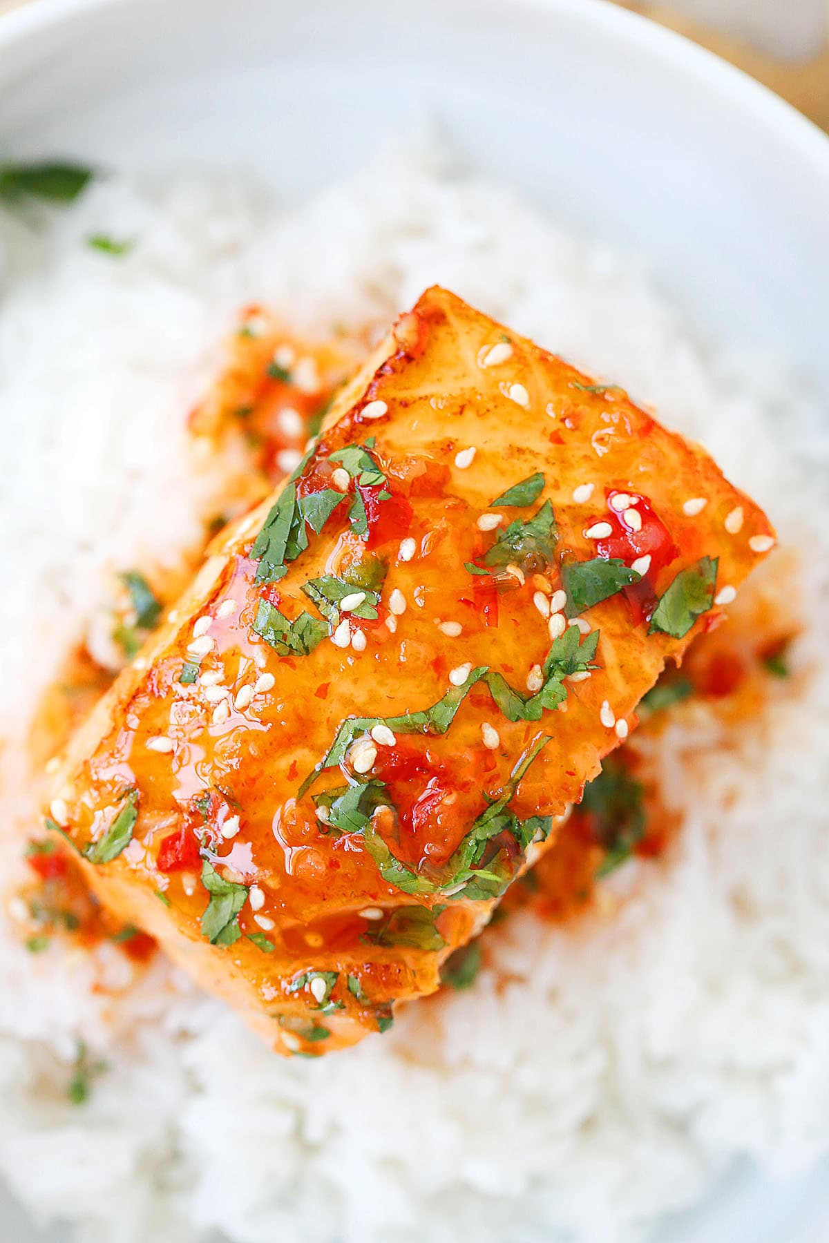 Pan-seared salmon with sweet chili sauce, garnished with cilantro.