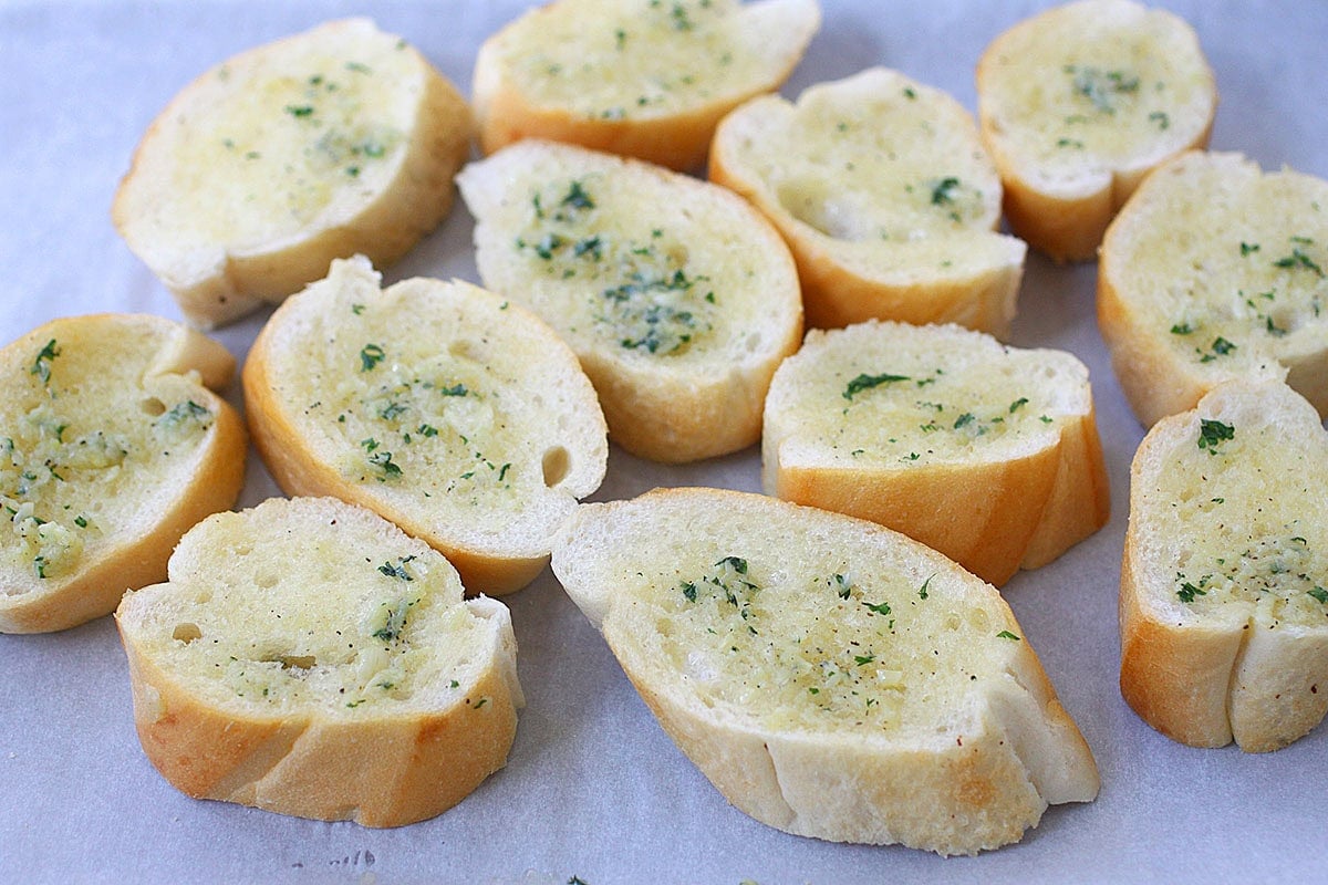 French bread slices coated in the garlic butter parsley mixture.