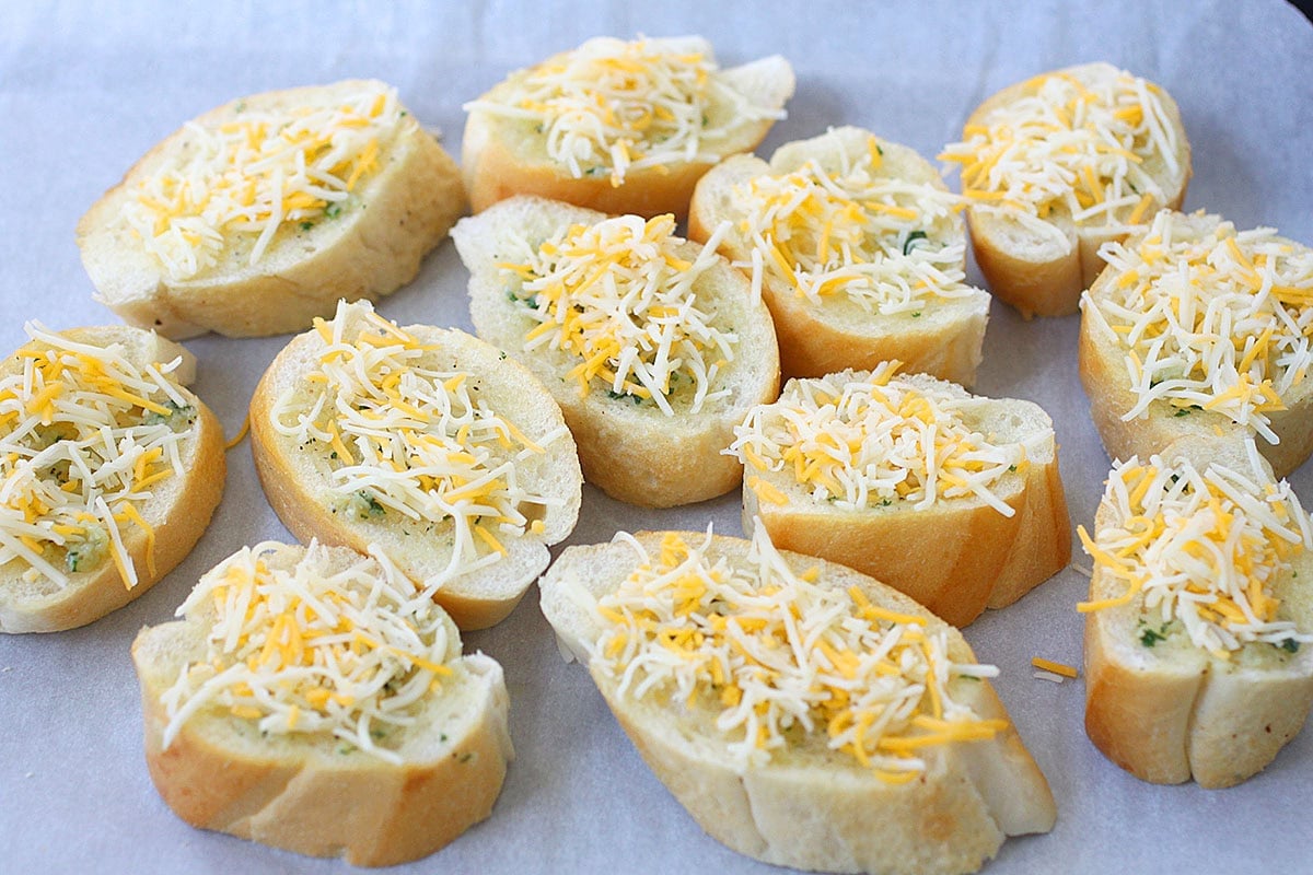 French bread slices with garlic butter and parsley, topped with a three-cheese blend.