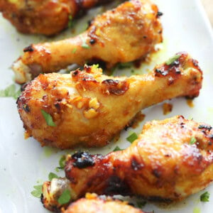 Crispy, glossy air fryer chicken drumsticks garnished with fresh parsley.