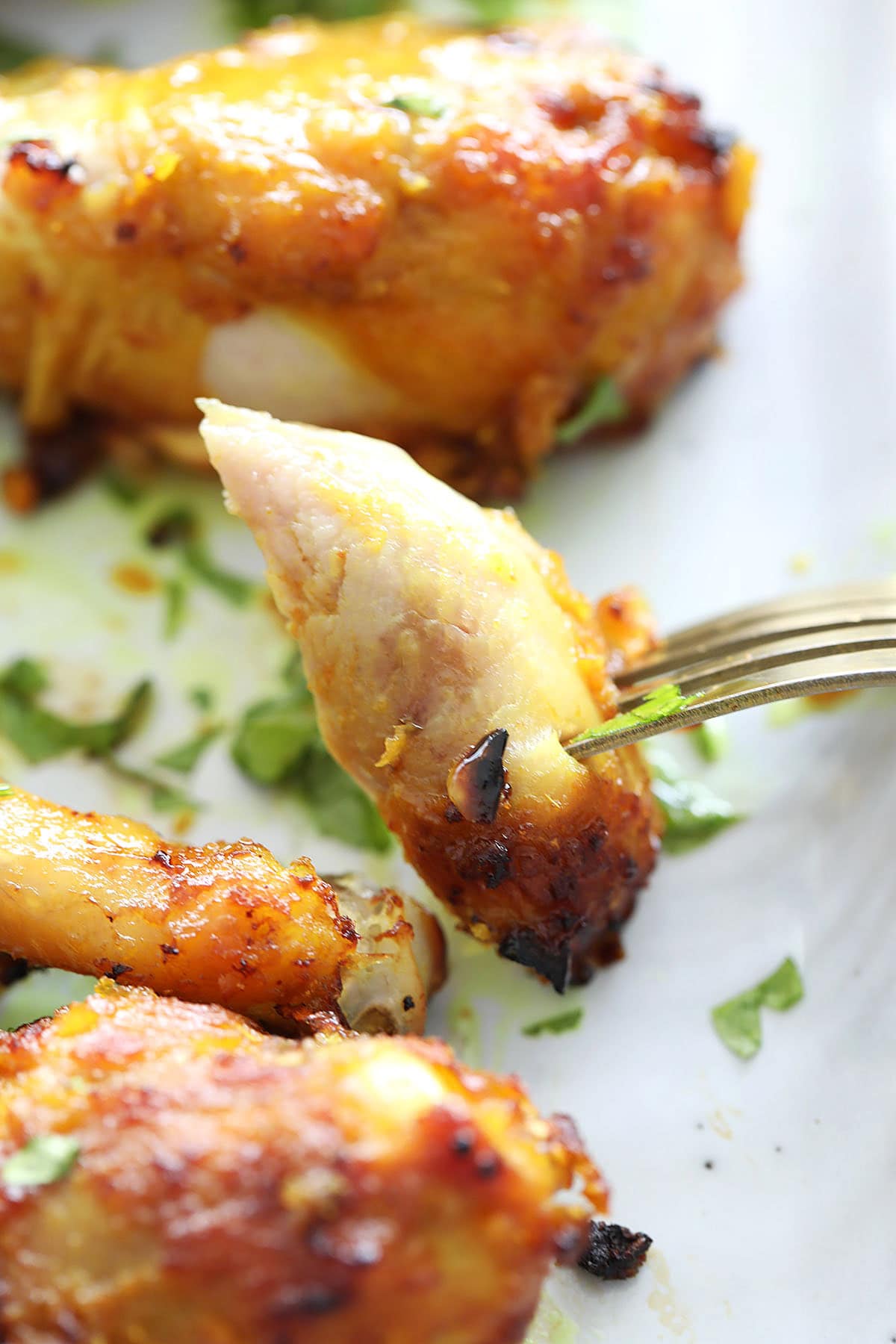 Fork piercing a juicy, golden air fryer chicken legs, revealing the tender inside.