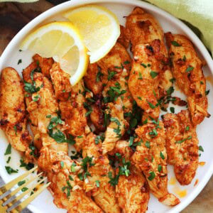 Air fryer chicken tenders with no breading, served on a plate.