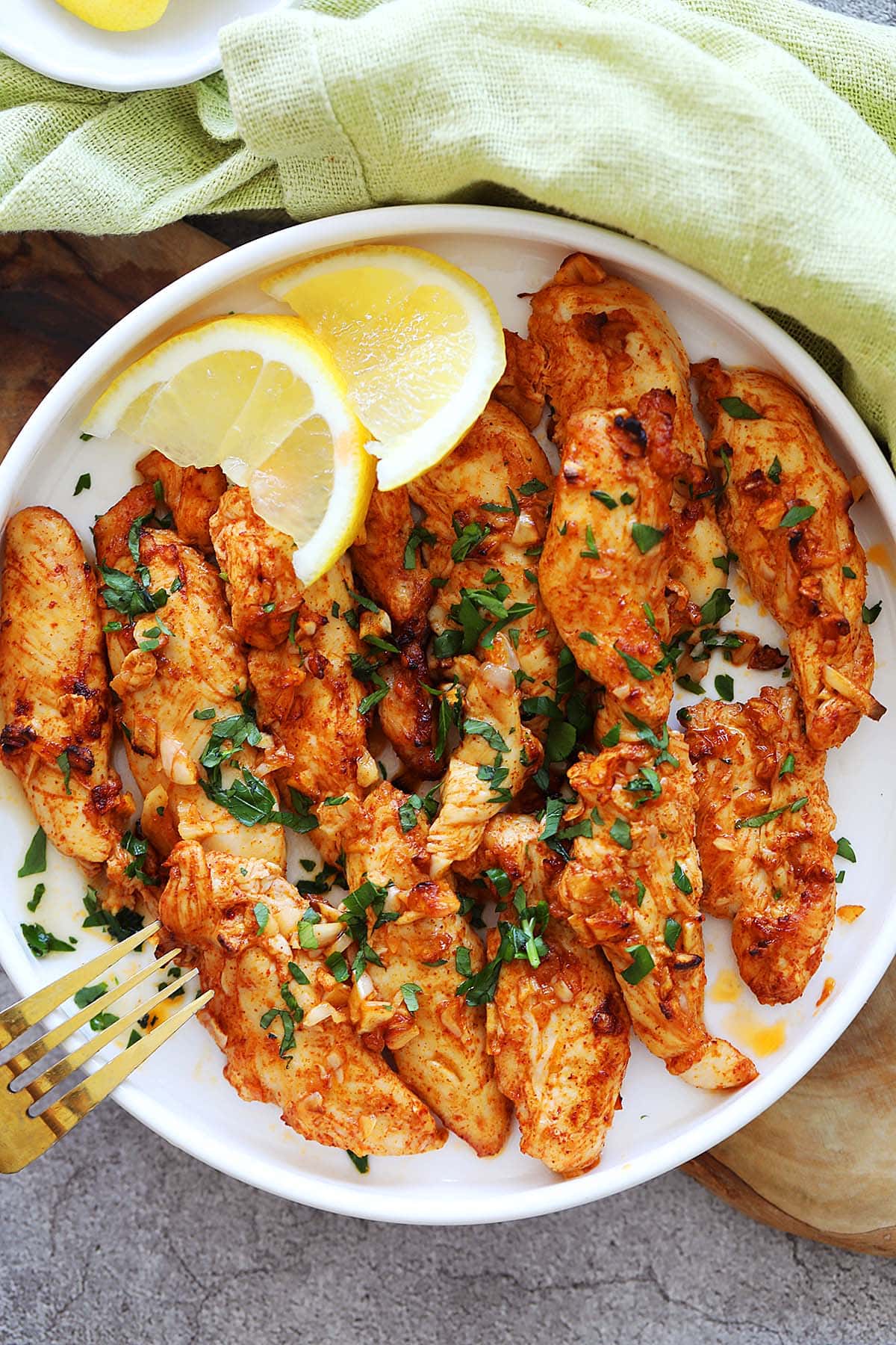 Air fryer chicken tenders with no breading, served on a plate.