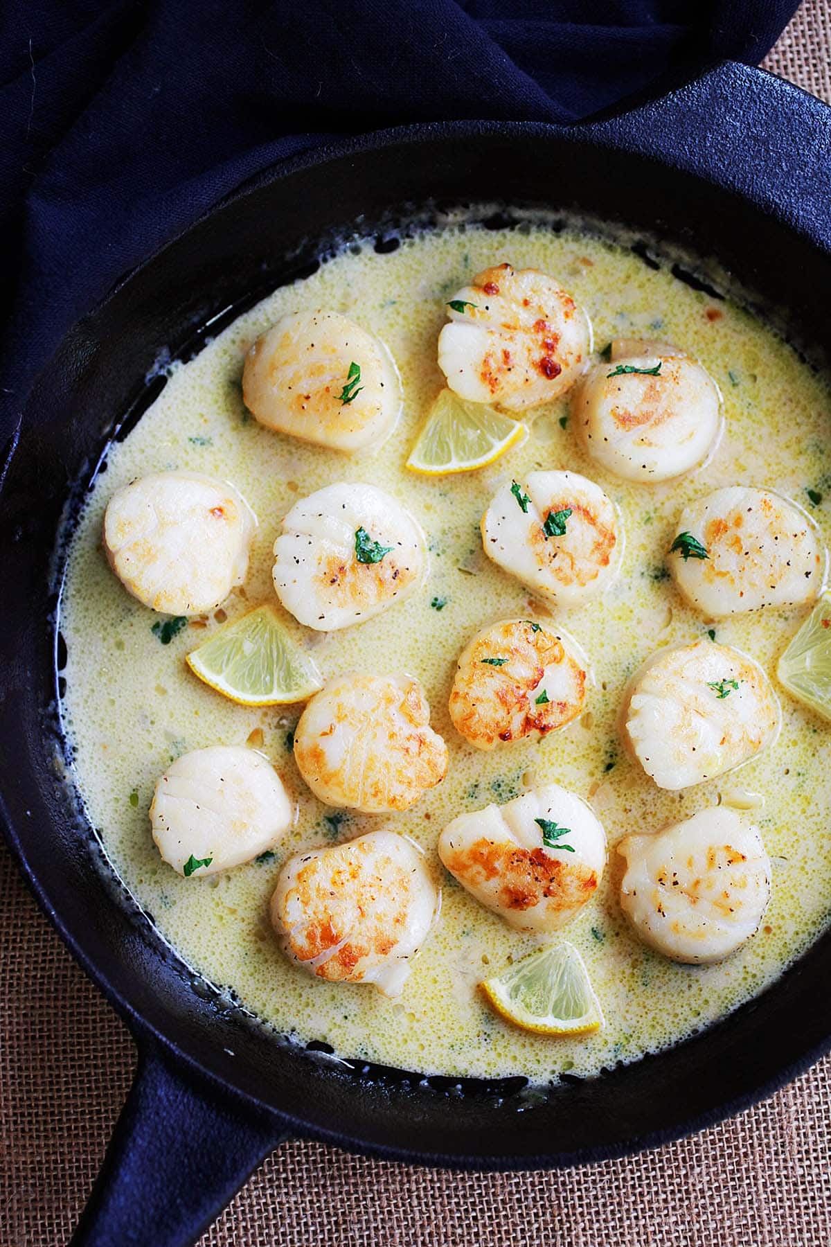 Creamy garlic scallops in a cast iron skillet.