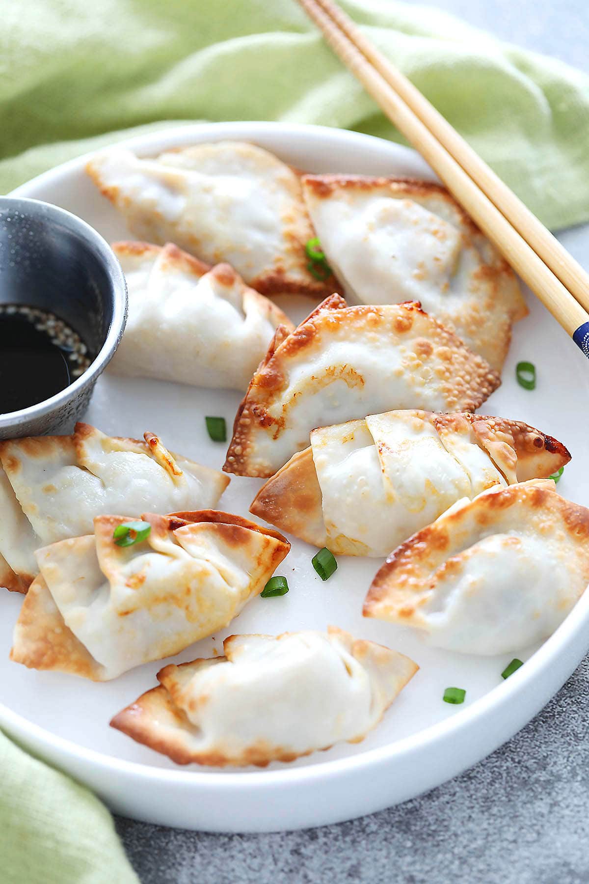 Crispy air fryer gyoza served on a plate with ponzu dipping sauce.