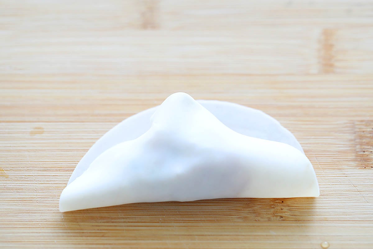 Gyoza wrapper folded in half over the filling.