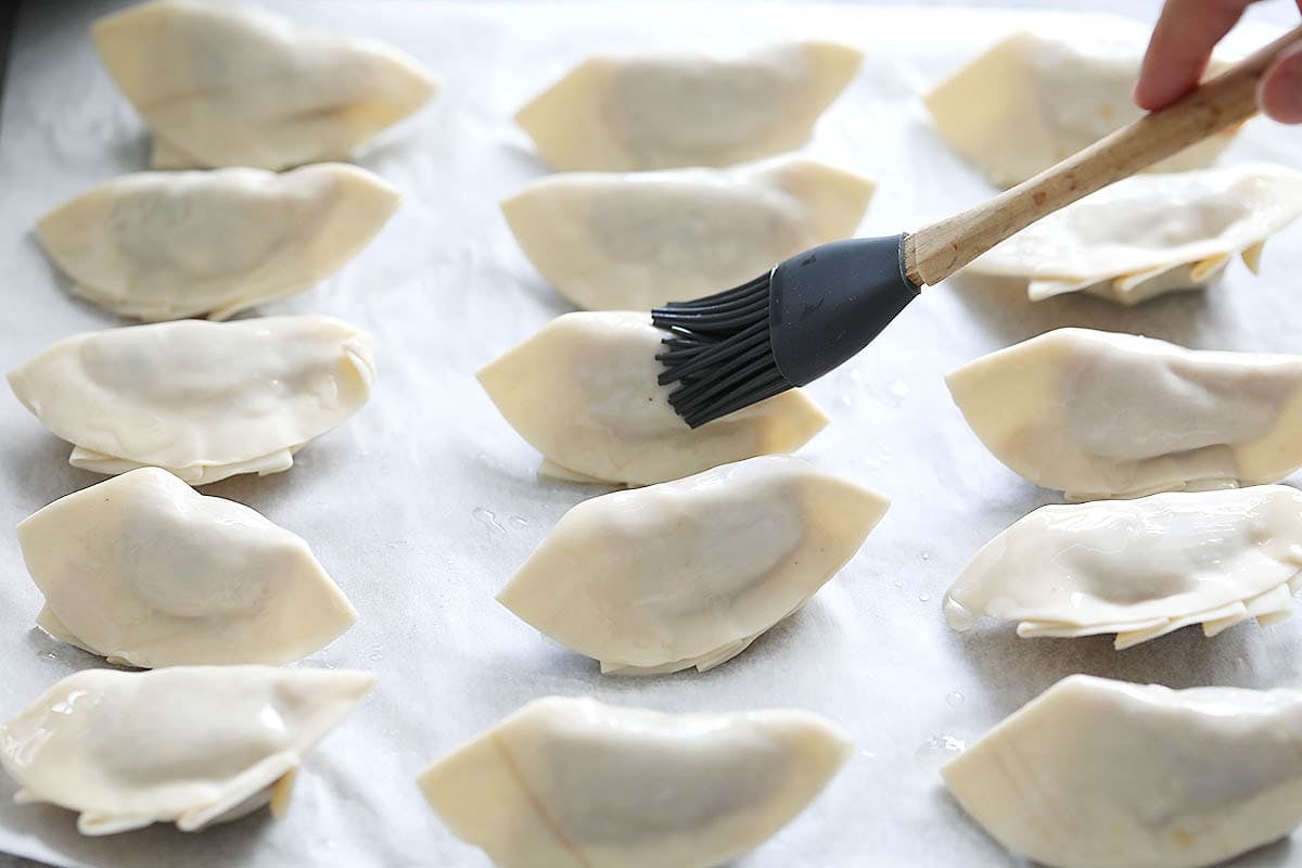 Uncooked gyoza brushed with oil.